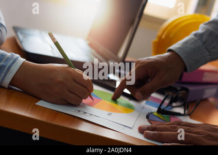 Two colleagues discussing and planing together with trade data chart document on office desk. Business and Office life concept. Stock Photo