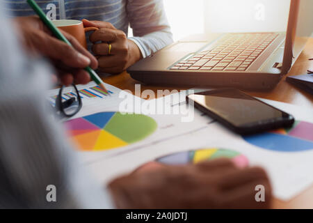 Two colleagues discussing and planing together with trade data chart document on office desk. Business and Office life concept. Stock Photo