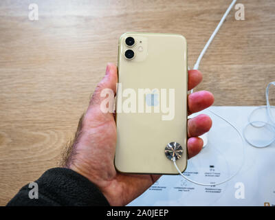 Paris, France - Sep 20, 2019: Man hand holding new new iPhone 11 displayed next to 11 Pro in in Apple Store as the smartphone by Apple Computers goes on sale Stock Photo