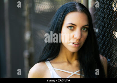 Beautiful young confident portrait of dark haired woman outdoor urban environment Stock Photo