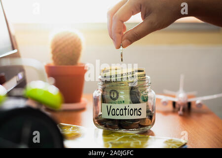 Hand of people holding coins putting in glass. Concept saving money for vacations. Financial concept. Stock Photo