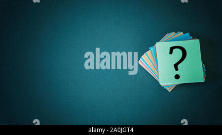 Stack of colorful papers with question marks on black background copy space Stock Photo