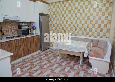 Kitchen corner sofa and table in the interior . design of orange white kitchen. soft corner with a table . Brown and white Kitchen design, refrigerato Stock Photo