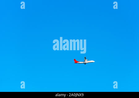 TAHITI, FRENCH POLYNESIA - SEPTEMBER 18, 2018: The plane against the blue sky. Isolated on blue background Stock Photo