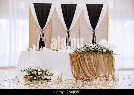 Wedding decorations in the great white hall of the restaurant. The groom's and bride's table. Stock Photo