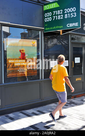 A man passes a closed Thomas Cook shop in Kingston Upon Thames, Surrey. The holiday company, with 150,000 holiday makers currently aboard on holiday, is holding last-minute negioatations to stop the bankruptcy of the company founded in 1872 Stock Photo