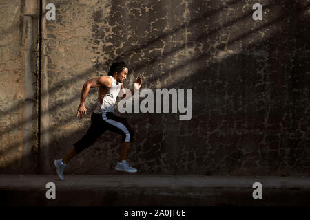 African-American man running on sidewalk Stock Photo