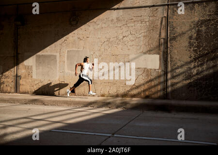 African-American man running on sidewalk Stock Photo