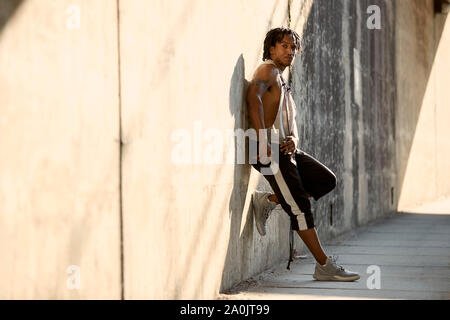 African-American man reaching for phone Stock Photo