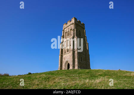 Top of Glastonbury Tor with  St Michael's Tower. Famous landmark. Historic english tower on the summit with blue sky, summer day. Beacon on hill. Stock Photo