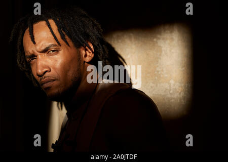 African-American man with dreadlocks looking at camera