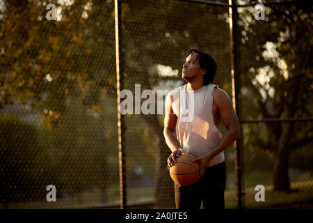 African-American man playing basketball outdoors Stock Photo