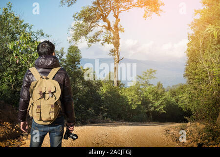Young professional traveler man with camera shooting outdoor, fantastic mountain landscape Stock Photo
