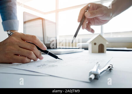 Architects engineer discussing at the table with blueprint - Closeup on hands and project print, Team group on construciton site check documents and b Stock Photo