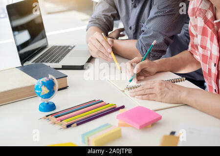 Young woman and man studying for a test/ an exam. Tutor books with friends. Young students campus helps friend catching up and learning. People, learn Stock Photo