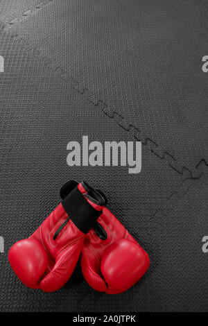 boxing gloves hang on nail on texture wall with copy space for text. Retirement concept Stock Photo