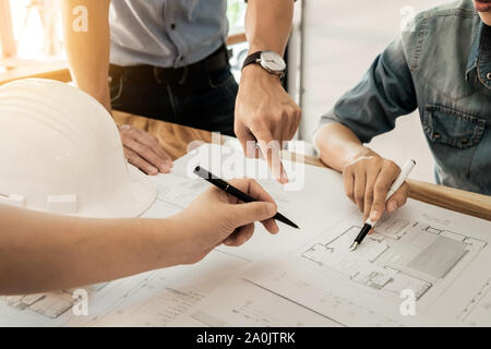 Architects engineer discussing at the table with blueprint - Closeup on hands and project print. Stock Photo