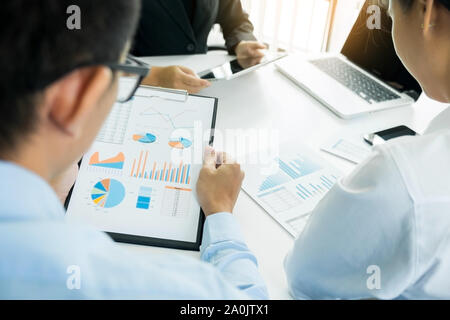 Team work process. young business managers crew working with new startup project. laptop on wood table, typing keyboard, texting message, analyze grap Stock Photo