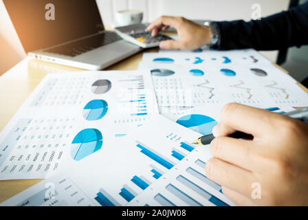 business man working at office with laptop, tablet and graph data documents on his desk. Stock Photo