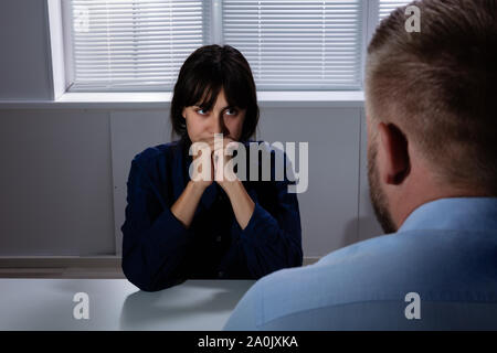 Man Sitting In Front Of Sad Worried Young Woman Suffering From Depression Looking Away Stock Photo