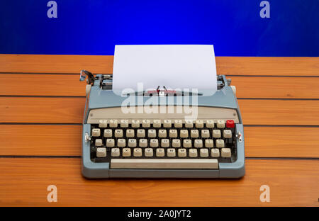 Old manual typewriter with white paper on wooden table, copy space banner Stock Photo