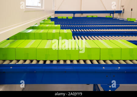 several conveyor belts with small green boxes on it Stock Photo