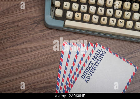 Manual typewriter with post card and envelopes on wooden background top view Stock Photo