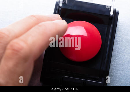 Close-up Of Person's Hand Emergency Bell On Table Stock Photo