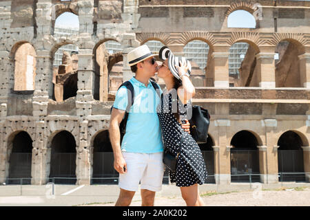 Young Tourist Couple Kissing In Front Of Colosseum In Rome, Italy Stock Photo