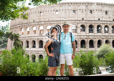 Young Tourist Couple Standing In Front Of Colosseum In Rome, Italy Stock Photo