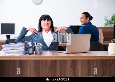 The two employees doing sport exercises in the office Stock Photo