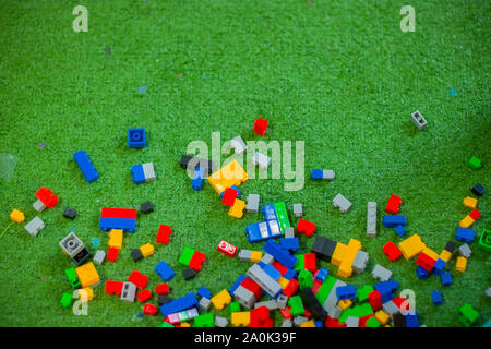 Colored toy bricks with place on green ground very messy. High resolution image gallery. Stock Photo