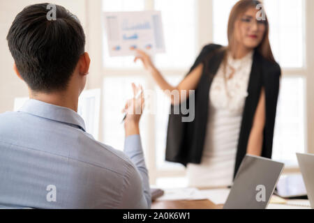 Business people raising there hand up at a meeting conference to answer a question and presenting there opinoin. Stock Photo