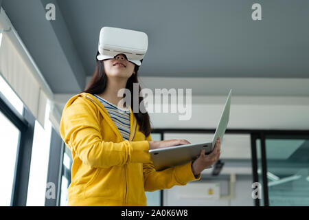 Young programmer or software developer with virtual reality glasses to testing 3D games and application. Technology and software development concept. Stock Photo