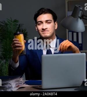 The employee working late and drinking strong coffee to stay awake Stock Photo