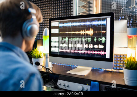 Waveform sound visualization on computer screen with audio editor in front Stock Photo