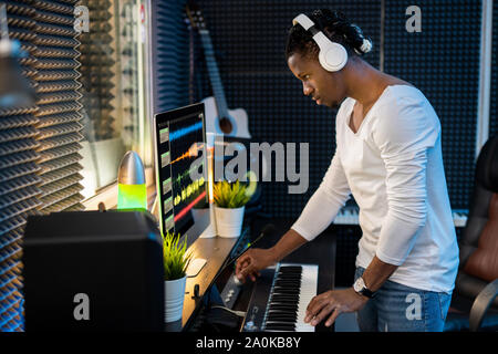 Confident young musician with headphones listening to mixed sounds in headphones Stock Photo