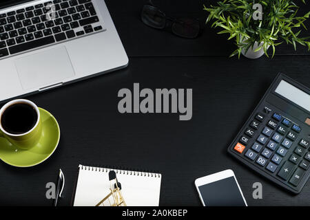 Gold cart, cash and gadgets on a black table. Stock Photo