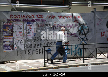Athens Greece Man Walking by Derelict Building with Graffiti on Stadiou Street Stock Photo