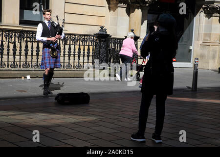 Glasgow Scotland Buchanan Street Bagpiper Busking Tourist Filming him on Smartphone Stock Photo