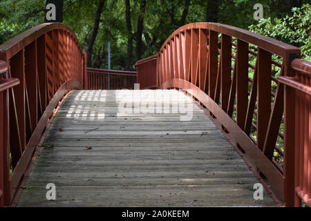 Pretty red bridge with tree canopy Stock Photo