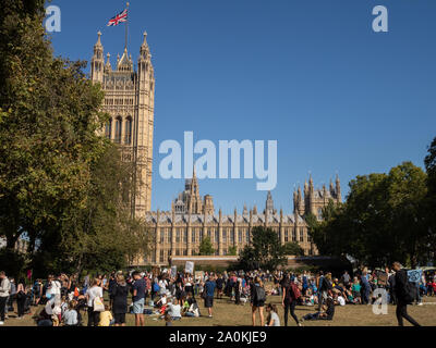 LONDON, UK - SEPTEMBER 20 2019: People at the Global Climate Strike in London, with Union Jack flag flying over the Houses of Parliament behind Stock Photo
