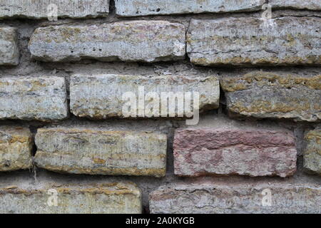 Destroyed by time and precipitation brick wall. The Background of old vintage brick wall Stock Photo