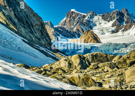 Walking on the ice and rocks of Franz Josef Glacier in the Southern Alps of New Zealand Stock Photo