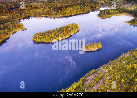 Forest lake with islands and sky reflection. Northern woodland aerial landscape Stock Photo