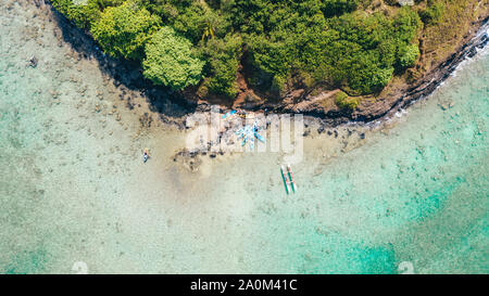 Kayaks and an outrigger canoe by Mokoli'i Island, in hawaii, USA Stock Photo