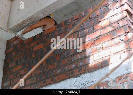 plasterer making up a brick wall with cement Stock Photo