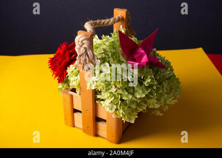 handmade crafted origami butterfly on a green bush in a basket on a colored background beautiful bouquet studio close shot Stock Photo