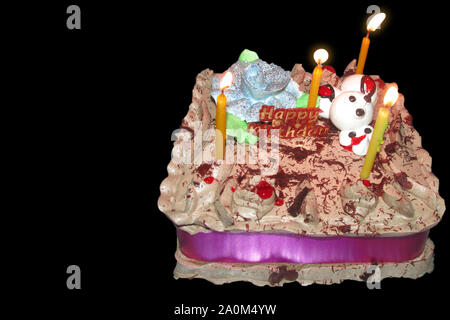 Birthday Drip Cake and burning candles with chocolate and sprinkles isolated black background banner with party decor. Celebration concept. Trendy Dri Stock Photo