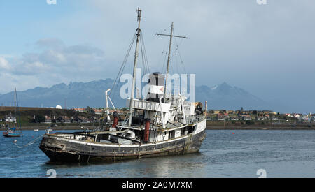 Ushuaia, Argentina - April 2 2019: An old British 2nd World War ship aground and a military neighborhood in the background. Stock Photo